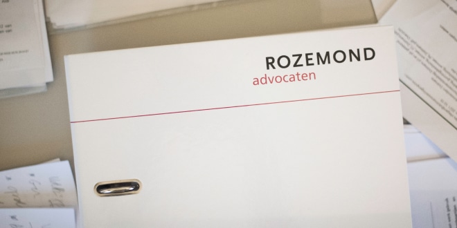 Een tafel vol papieren dossiers en een map van Rozemond Advocaten.